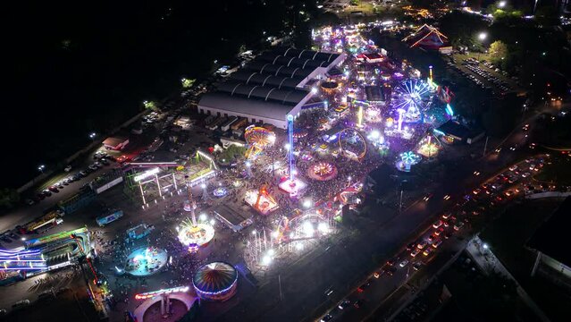 Arerial view over a large fair ground in Villahermosa city Tabasco at night, drone orbital hyperlapse, M&eacute;xico, ferris wheel.  Side amusement&nbsp;parks. Tabasco Fair