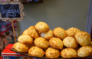 Fresh baked pastries and sweets on display in artisan Spanish confectionery shop, coconut cakes
