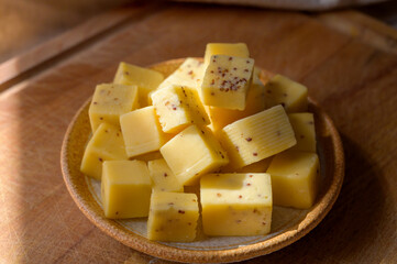Cheese collection, matured yellow cow cheese cubes with mustard seeds from Belgium