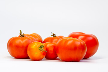 Fresh tomatoes on a white background. Red bright tomatoes, healthy vegetarian food.