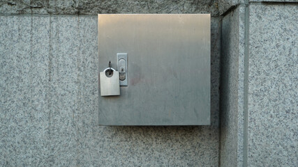 Locked Metal Electric Panel Board on the Street Stone Wall