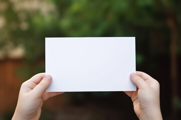 Kid's Hands Holding Blank Horizontal White Card Mockup with Nature Background, Empty Paper Template, Perfect for Invitations, Greetings Product Presentation. Generative AI