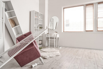 Armchair with folding screen and dressing table in messy room