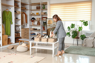 Young woman choosing shoes in light boutique