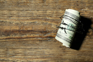Dollar banknotes with barbed wire on wooden background. Sanctions concept