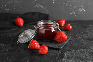 Jar of sweet strawberry jam and fresh berries on table