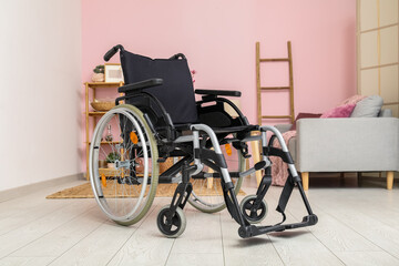Fototapeta na wymiar Modern empty wheelchair in living room near color wall