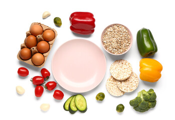 Empty plate, vegetables, eggs and bowl of oatmeal on white background