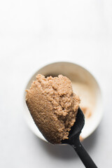 Creamed butter and brown sugar on a spatula, butter sugar and cinnamon mixed on a spatula, mixing butter and sugar to make cinnamon roll filling, the process of making a cake