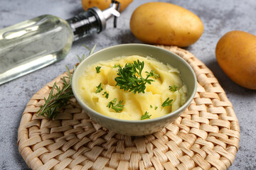 Bowl of tasty mashed potatoes with parsley and rosemary on blue background