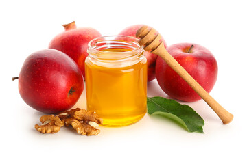 Jar of honey with walnut, apples and pomegranate for Rosh Hashanah celebration (Jewish New Year) on white background