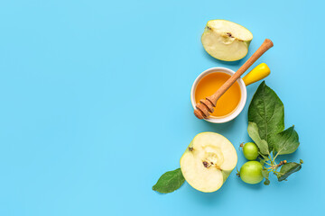 Bowl of honey and apples for Rosh Hashanah celebration (Jewish New Year) on blue background