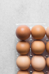 Top view of a crate of eggs on a marble surface, Eggs in a transparent plastic crate, organic eggs on a table
