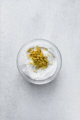 Lemon zest and granulated sugar in a glass bowl, lemon sugar for baking in a transparent bowl, process of making lemon dessert