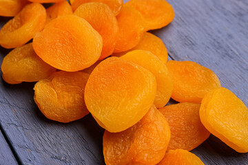 Tasty dried apricots on blue wooden background