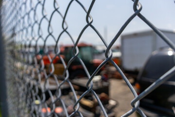 Side view of metal fence with vehicles behind - blurred background. Taken in Toronto, Canada.