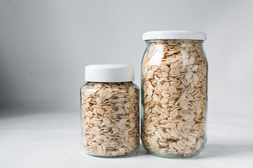 nigerian egusi seeds in a glass jar, shelled melon seeds in a transparent jar, nigerian melon seeds, pumpkin seeds for cooking
