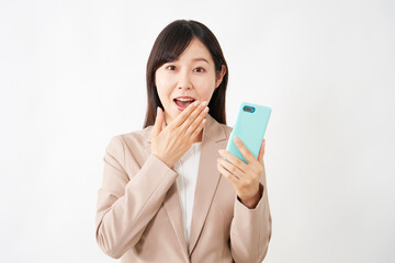 スマートフォンを持って驚くミドルエイジのビジネスウーマン　白背景
