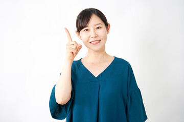左側を指差すミドルエイジの女性　白背景