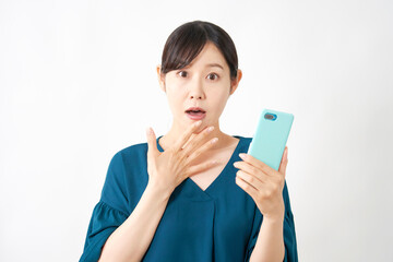スマートフォンを持って驚く女性　白背景