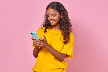 Young cheerful Indian woman with black hair holding phone using mobile apps for shopping and...