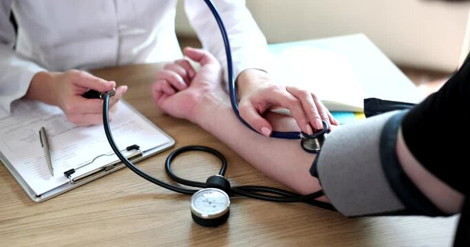 The woman measures the doctor with tonometer pressure to the man, close-up. Medical instruments, therapy
