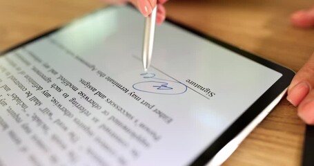 Women's hands put an electronic signature on a document in a tablet, close-up. Digital document management