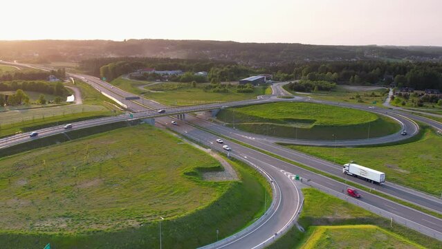 Highway S6 in Kielno, Gdynia, Poland - aerial flyover. Multi-lane Highway with Ramps and Light Traffic with Truck and Cars Traveling Both Ways At Golden Hour
