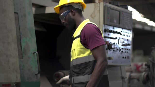 African American Mechanical engineer working to checking repair and maintenance old machine in factory industries . black labor worker man control machine in warehouse Workshop