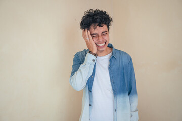 Young curly man wear denim clothes feel toothache and painful. The photo is suitable to use for man expression advertising and fashion life style.
