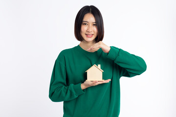 Young asian woman smiling wear green shirt holding house sample model isolated on white background, Real estate and home insurance concept