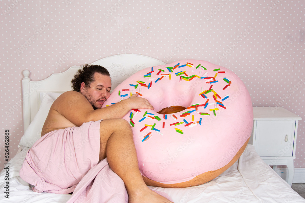 Wall mural Diet and sweet snacks. Funny fat man dreams about donuts and cakes.