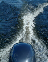 Close-up on a cruising outboard engine kicking up a descent wake in the waters of the Zambezi River