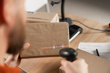 Worker scanning package in warehouse with barcode scanner check goods in transportation and...