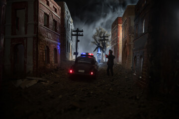 Police raid at night and you are under arrest concept. Silhouette of handcuffs with police car on...