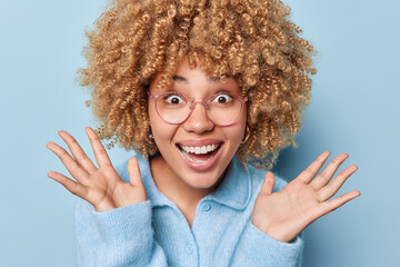 People and happiness. Studio close up of young cheerful smiling African model isolated on blue...