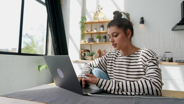 The girl is typing a text on the laptop, completes her work, and closes it.