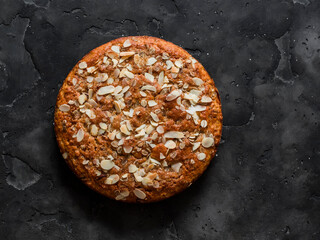 Oatmeal, chocolate, greek yogurt cake on a dark background, top view
