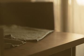 linen napkin on a wood table closeup with evening sunlight