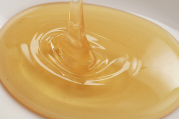 Closeup shot of organic honey pouring in bowl