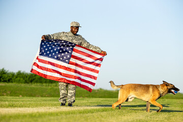Soldier in uniform holding USA flag celebrating Independence day with his military dog.