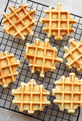 Freshly baked waffles on a baking rack.