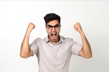 Excited young man celebrating success making fist pump move and shouting happy winning and rejoicing white background