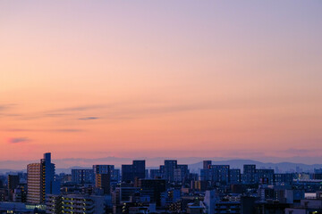都市の夜明け前。太陽が昇る前に東の空がオレンジ色に輝くマジックアワー。