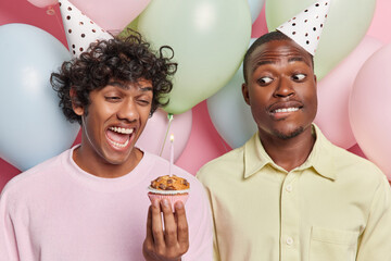 People celebration and positive emotions. Studio photo of two cheerful men enjoy birthday party...