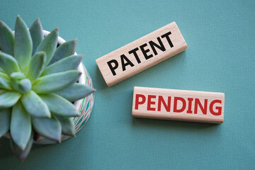 Patent Pending symbol. Concept word Patent Pending on wooden blocks. Beautiful grey green...
