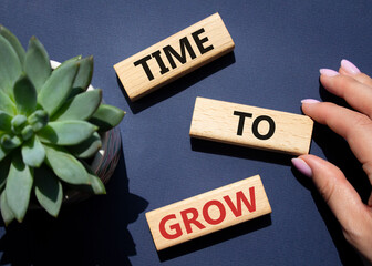 Time to Grow symbol. Concept word Time to Grow on wooden blocks. Businessman hand. Beautiful deep...