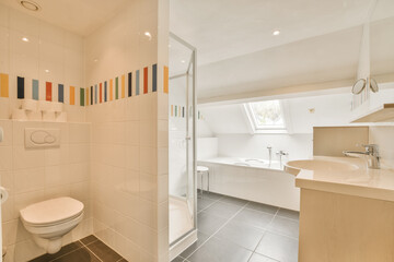 a bathroom with tiled walls and white tiles on the floor, there is a toilet in the corner next to the sink