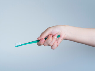 歯ブラシを持つ女性の手