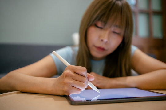 Woman take notes and drawing a digital illustration on a tablet computer